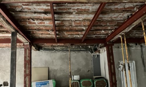 Estructura de hierro, ladrillos y maquinaria en una obra de reforma