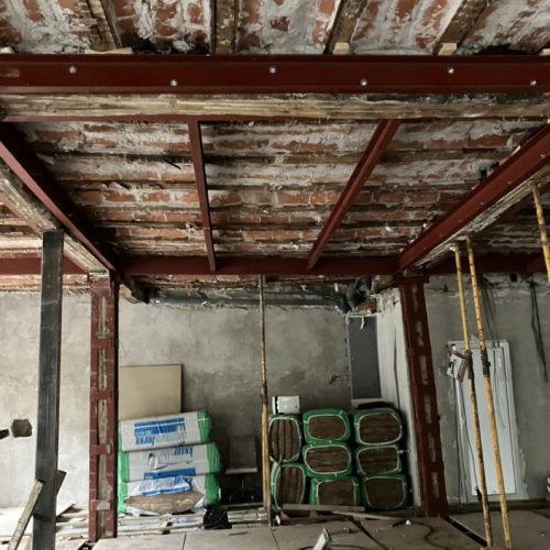 Estructura de hierro, ladrillos y maquinaria en una obra de reforma