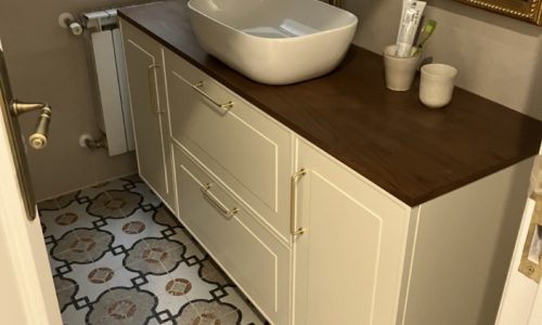 Mueble de baño en color blanco con lavabo sobreencimera y detalles en madera