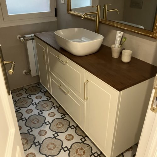 Mueble de baño en color blanco con lavabo sobreencimera y detalles en madera