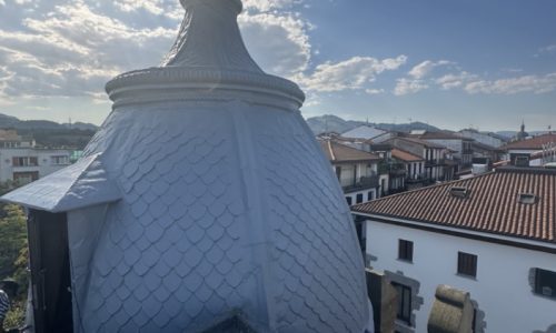 Cúpula de techo con tejas en rehabilitación y vista de urbanización