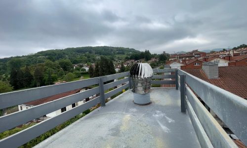 Chimenea en un tejado con vista del paisaje