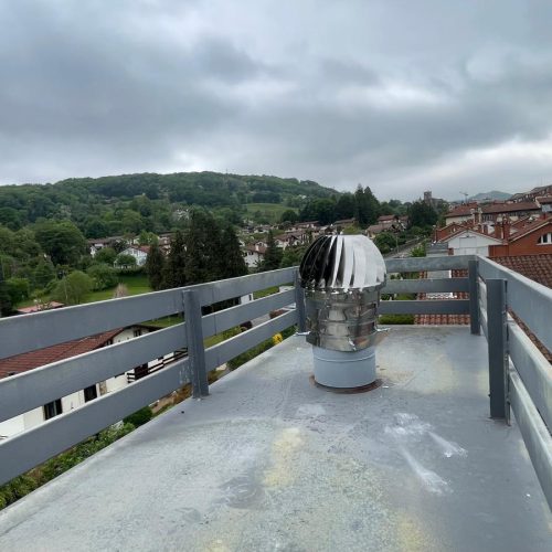 Chimenea en un tejado con vista del paisaje