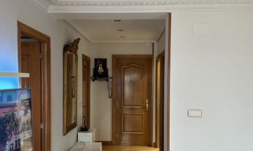 Pasillo con paredes pintadas y puertas de madera en una vivienda reformada